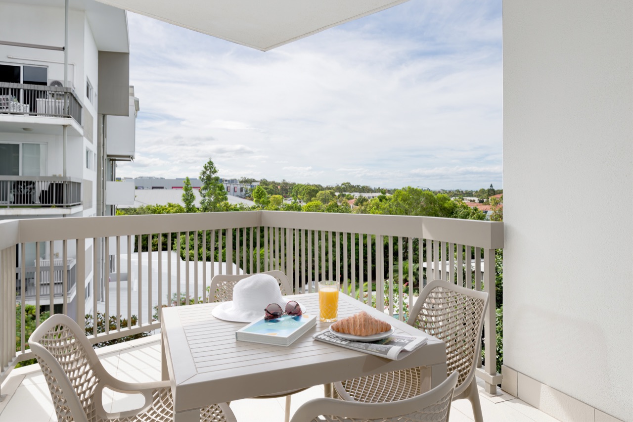 Balcony set for breakfast with coffee, juice and a magazine