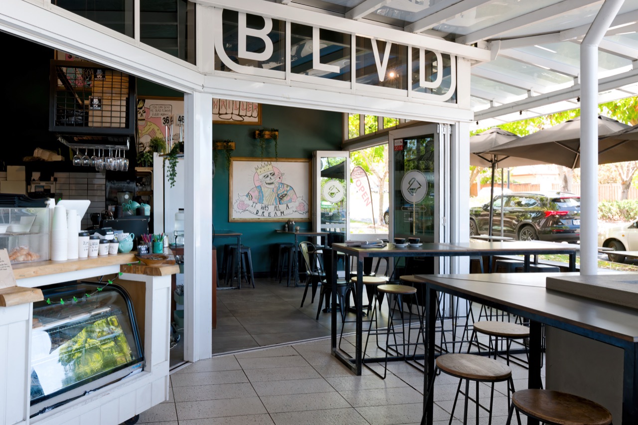 Interior of the BLVD cafe at street level, with a feature wall and street-facing windows
