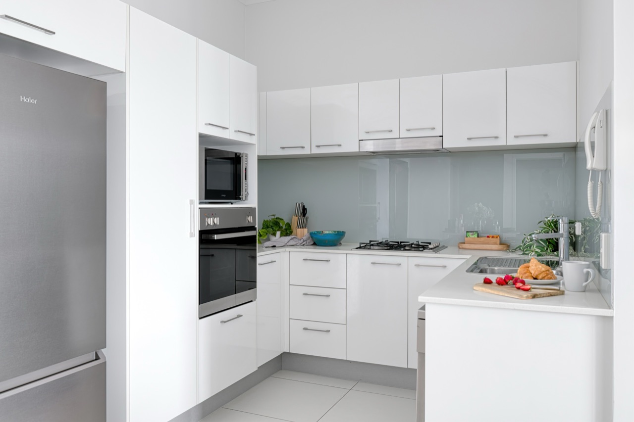 Penthouse kitchen with glass splashback and full-size appliances