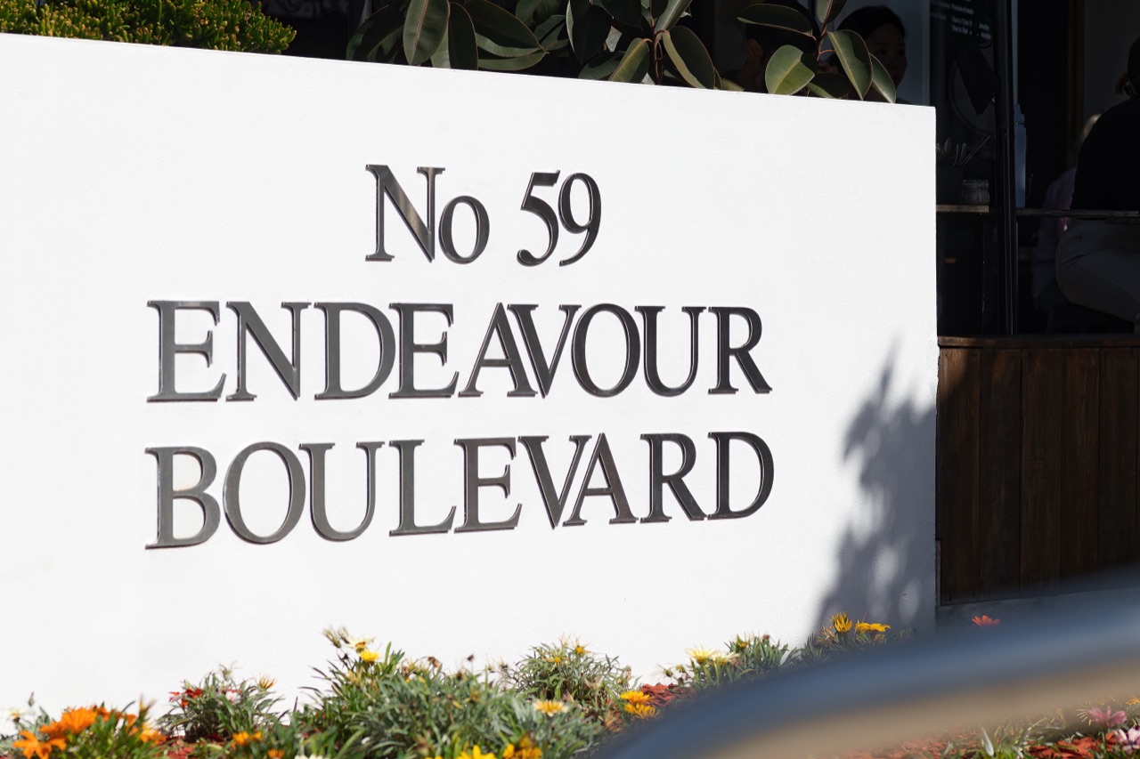 Street address plaque reading 59 Endeavour Boulevard beside a garden bed