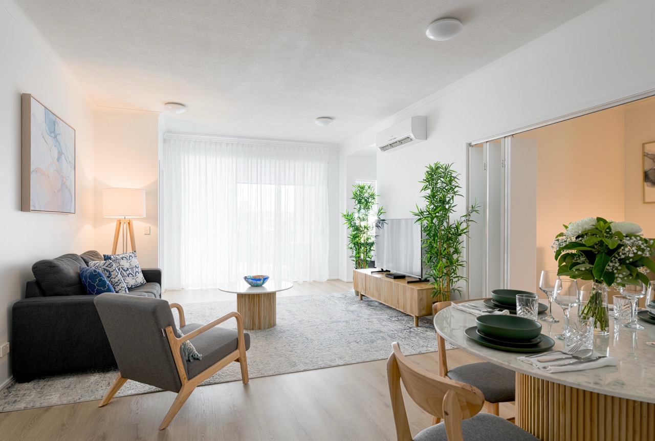 Living area in the study apartment with timber floors and sheer curtains